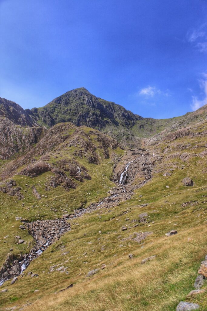 green grass covered mountain under blue sky during daytime