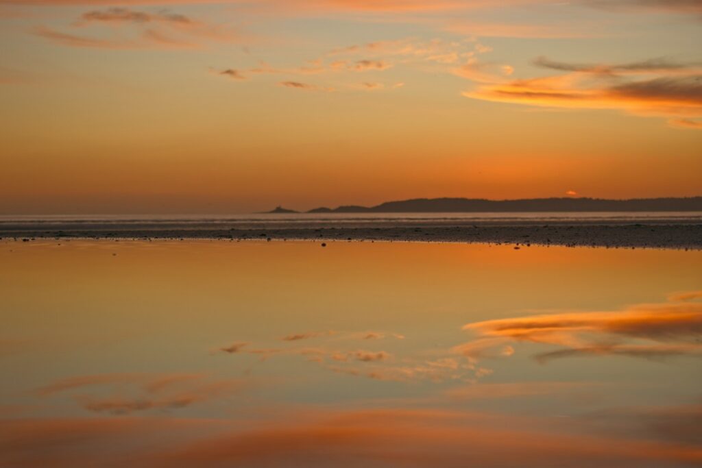 a large body of water sitting under a cloudy sky
