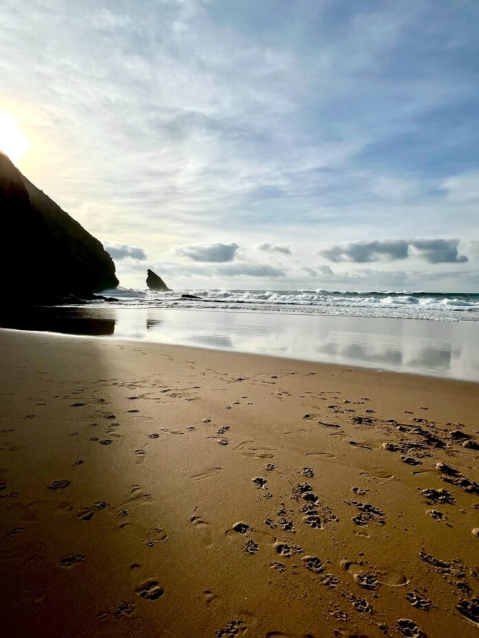 a sandy beach with footprints in the sand